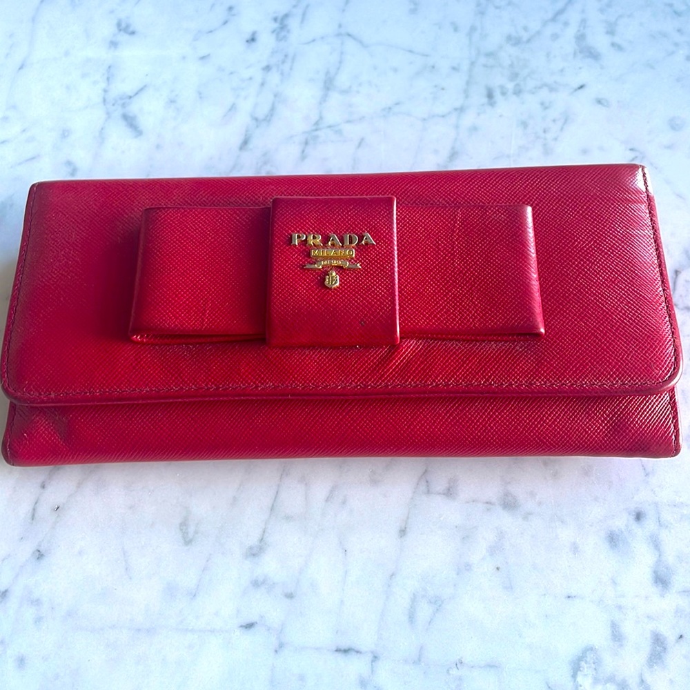 Prada Red Saffiano leather wallet with a bow accent.